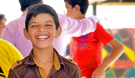 A young refugee of the Syrian civil war flashes a smile, demonstrating his resilience.
